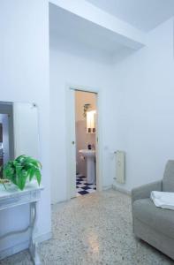een witte woonkamer met een bank en een wastafel bij Home Bernadette in Rome