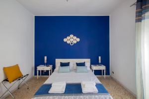 een blauwe slaapkamer met een groot bed en 2 tafels bij Home Bernadette in Rome