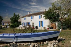 un barco azul sentado frente a una casa en MOULIN DE MAUZAC, en Saint-Just