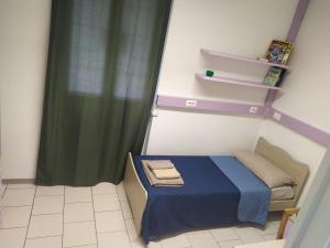 Habitación pequeña con cama azul y cortina en La Quiete, en Senna Comasco