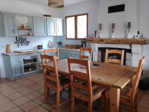 a kitchen with a wooden table and chairs at La rivière in Damazan