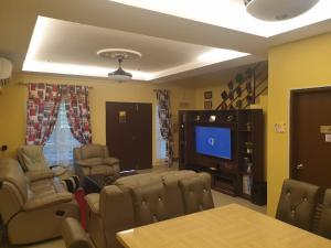 uma sala de estar com cadeiras e uma televisão de ecrã plano em Mountain View Homestay em Seremban