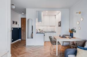 a kitchen and a living room with a table and chairs at Prime Plac Unii in Gdynia