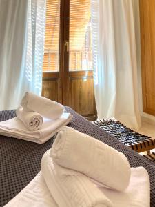 Dos toallas blancas sentadas en una cama en una habitación en La Fonda del Arco, en Guadix