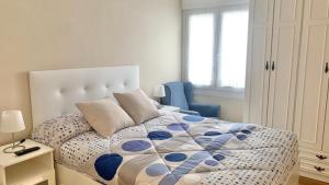 um quarto com uma cama e uma cadeira azul em APARTAMENTO en MUNDAKA con GARAJE em Mundaka