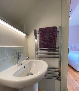 a bathroom with a sink and a towel rack at The Hayloft, Exmoor in Withypool