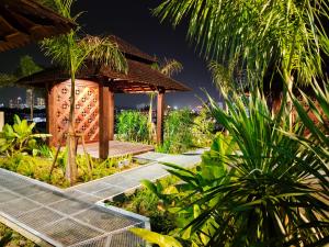 um jardim com um gazebo num resort em Bali Residences Homestay Melaka Town em Malaca