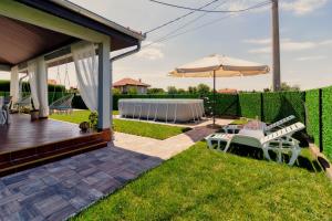 a patio with a table and an umbrella at Green Art House in Kovilovo