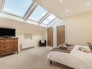 a bedroom with a bed and a skylight at Brick Kiln Cottage in Burton Overy