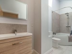 a bathroom with a sink and a toilet and a mirror at Brick Kiln Cottage in Burton Overy