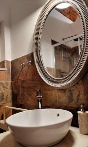 uma casa de banho com um espelho grande e um lavatório em Casa Victoria em Olhão