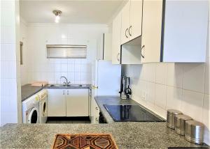 a white kitchen with a sink and a refrigerator at Bondi Beach D in Shelly Beach