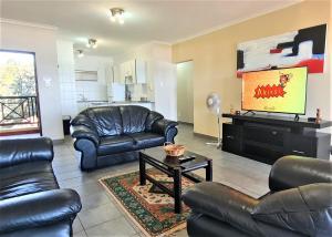 a living room with leather furniture and a television at Bondi Beach D in Shelly Beach