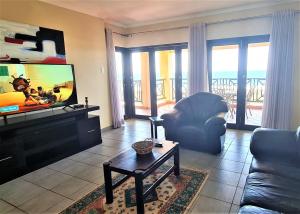 a living room with a couch and a flat screen tv at Bondi Beach D in Shelly Beach