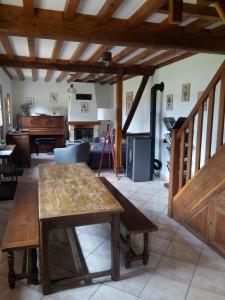 a living room with a table and a piano at La bergerie, cottage normand 5 pers. avec piano in Épreville-en-Lieuvin