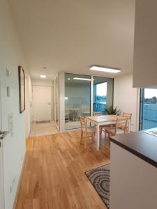 una cucina e una sala da pranzo con tavolo e sedie di Neu erstellte Wohnung mit Balkon in Hard a Hard