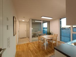 cocina y comedor con mesa y sillas en Neu erstellte Wohnung mit Balkon in Hard, en Hard