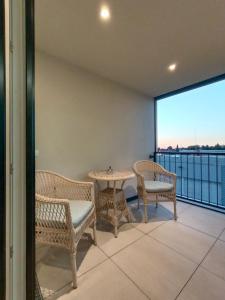 balcón con mesa, sillas y vistas en Neu erstellte Wohnung mit Balkon in Hard, en Hard