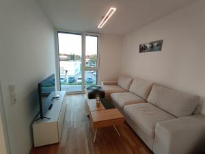 sala de estar con sofá blanco y mesa en Neu erstellte Wohnung mit Balkon in Hard, en Hard