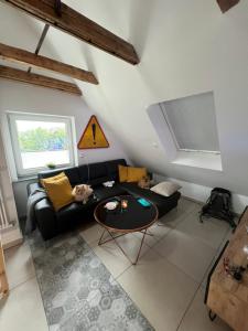 a living room with a black couch and a table at Nowe miasto in Wałbrzych