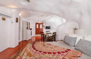 a bedroom with a bed and a table with chairs at Traditional Farmers Caves in Emporio