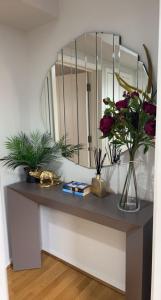 stół z kwiatami i lustrem w obiekcie The Reflection Apartment , With river Thames view w mieście North Woolwich