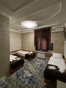 a room with two beds and a window in it at DAVAN in Koshkurgan