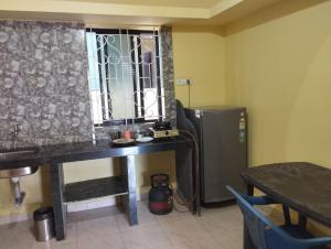 a room with a desk and a refrigerator and a table at PARVATI MANDREM in Mandrem