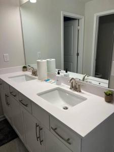 a bathroom with two sinks and a large mirror at New spacious 3 bedroom suite garage parking free Wi-Fi office space and patio view in Duluth