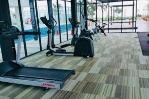 un gimnasio con cintas de correr y bicicletas estáticas en C 1-5 Pax Cozy home Studio 3Bed WIFI&TV Trefoil Setia Alam SCCC, en Setia Alam