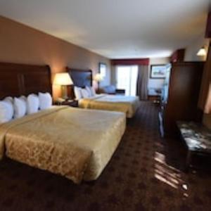 um quarto de hotel com duas camas e um sofá em Hamilton Inn Select Beachfront em Mackinaw City