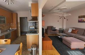 a kitchen and living room with a couch and a table at Delux apartment Moj Osijek, SELF CHECK-IN in Osijek