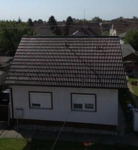 een wit huis met twee ramen en een dak bij Apartman Ana 1 in Valpovo