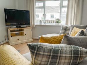 a living room with two couches and a flat screen tv at White Hart Cottage in Ulverston