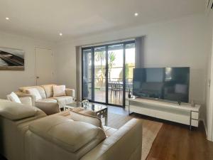 a living room with two couches and a large flat screen tv at Bliss on the Bay Cheerful townhouse in Torquay in Torquay