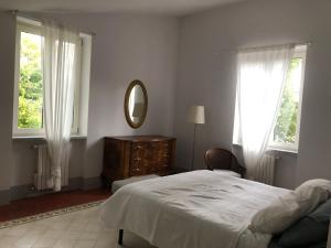 - une chambre avec un lit, un miroir et des fenêtres dans l'établissement Nel Giardino di Ester B&B, à Barile