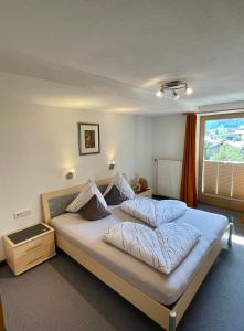 a bedroom with a large bed with a window at Ferienwohnung Rauch in Schwendau