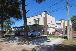 a house with a car parked in front of it at Dunas Delfin in Monte Hermoso