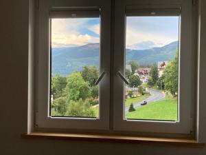 a window with a view of a road and mountains at Apartament Tymon in Karpacz