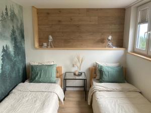 two twin beds in a room with a table at Apartament Tymon in Karpacz
