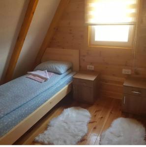 een slaapkamer met een bed, een raam en 2 tapijten bij Bungalovi 3AS in Žabljak