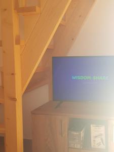 een tv op een houten kast op zolder bij Bungalovi 3AS in Žabljak