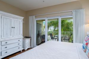 a bedroom with a bed and a balcony at Harbour House at the Inn 314 in Fort Myers Beach
