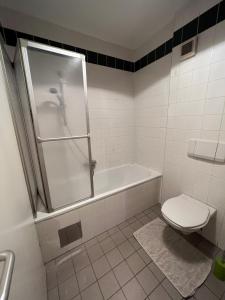 a bathroom with a shower and a toilet and a tub at Cosy apartment in central location in Vienna