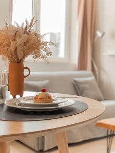 a table with a plate with a cake on it at Le Seize - Studio dans le centre historique d'Auch in Auch