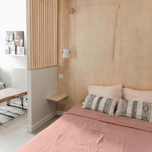 een slaapkamer met een bed met roze lakens en kussens bij Le Seize - Studio dans le centre historique d'Auch in Auch