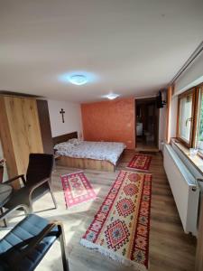 Zimmer mit einem Bett und zwei Teppichen auf dem Boden in der Unterkunft Casa Rustica in Borşa