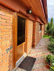 ein Backsteingebäude mit einer Holztür und einem Ziegelsteinweg in der Unterkunft Casa Rustica in Borşa