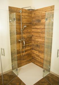 eine Dusche mit einer Holzwand im Bad in der Unterkunft Apartment White der Sportschule Badura in Leipzig