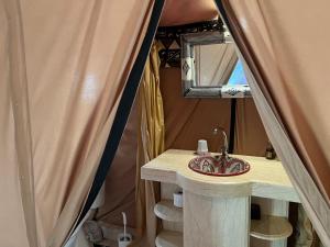een badkamer met een wastafel en een spiegel bij Luxury traditional Tent Camp in Merzouga